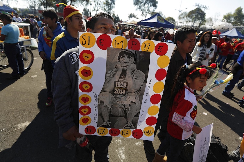A man holds a poster with a picture of 'El Chavo del Ocho', a character created by screenwriter Roberto Gomez Bolanos, as he waits to enter the Azteca stadium for a mass in memory of Gomez Bolanos in Mexico City November 30, 2014. u00c2u00a0u00e2u20acu201d Reuters pic