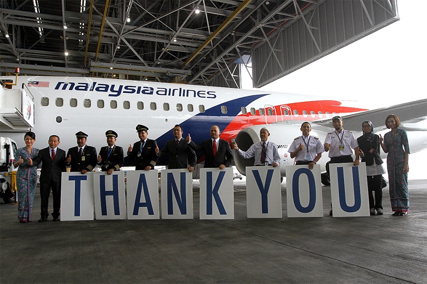 Pilots and crew members of MAS' 100th Boeing 737 aircraft hold up cards spelling out a 'thank you' message after the aircraft arrived at KLIA in Sepang, December 22, 2014. u00e2u20acu201d Picture by Yusof Mat Isa