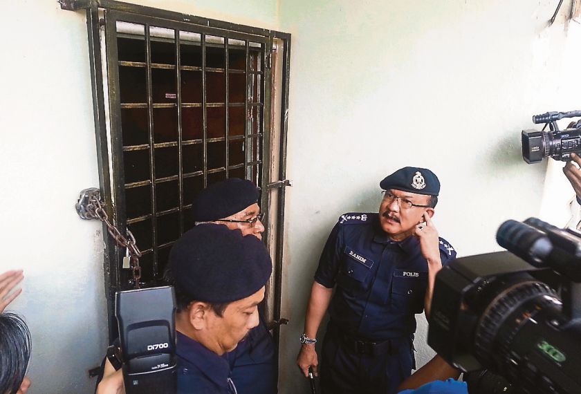 Abdul Rahim (right) and his men outside the house where the murders took place. u00e2u20acu201d Picture by Malay Mail