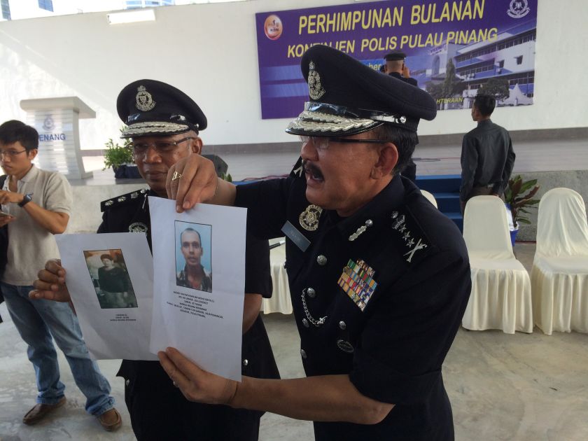 Penang police chief Datuk Abdul Rahim Hanafi (right) shows pictures of men the police are looking for to assist investigations into the Myanmar murder cases. u00e2u20acu201d Picture by Opalyn Mok