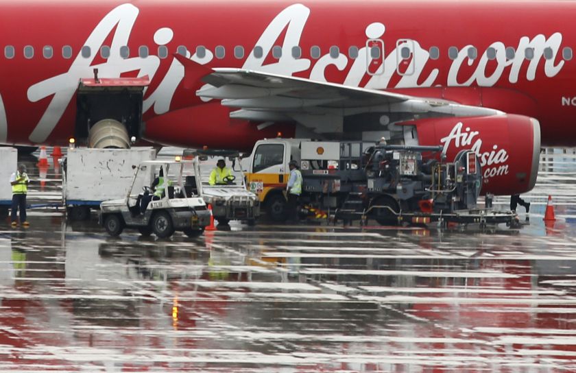 Staff members unload AirAsia's QZ8501 from Surabaya to Singapore, which took the same code as the missing plane that took off 24 hours earlier, at Changi Airport in Singapore December 29, 2014. u00e2u20acu2022 Reuters pic