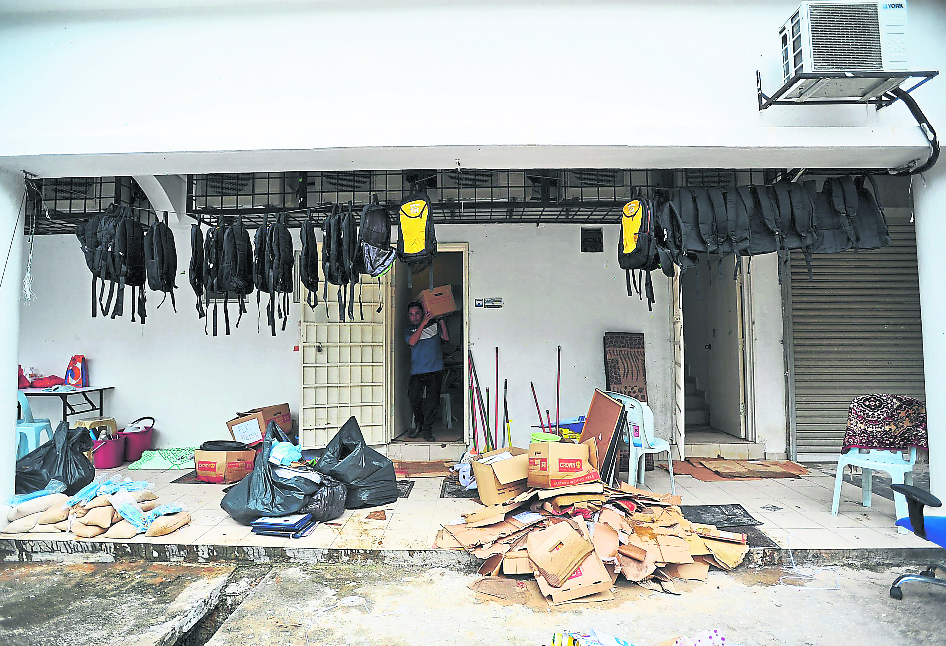Boxes of goods outside a building after they were destroyed during the floods, while wet bags are hung out to dry.n