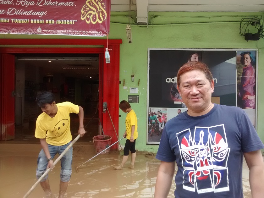 Gan Soon Hoe, 45, owner of MySports, helps his staff to clean the mud at his shop in Jalan Temenggong, December 30, 2014. u00e2u20acu201d Picture by Syed Jaymal Zahiid