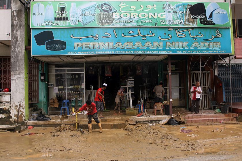 Men shoveling mud from and cleaning the entrance of a shop in Kota Baru as flood levels begin to subside in Kelantan, December 30, 2014. u00e2u20acu201d Picture by Yusof Mat Isa