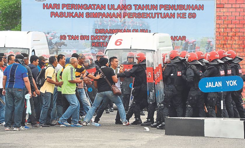 Federal Reserve Unit personnel demonstrate how they control a riot at the 59th anniversary celebrations of the unit launched by Khalid in Cheras yesterday. u00e2u20acu201d Picture by Bernama