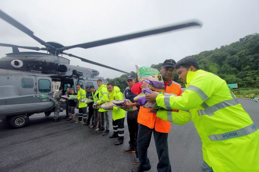 Chairman of Umnou00e2u20acu2122s Welfare Agency Datuk Seri Abdul Azeez Abdul Rahim (2nd right) joins volunteers in loading food into a TUDM helicopter that is set to distribute food and other necessities to flood victims in Gua Musang, Dec 26 2014. u00e2u20acu201d Bernama pic 