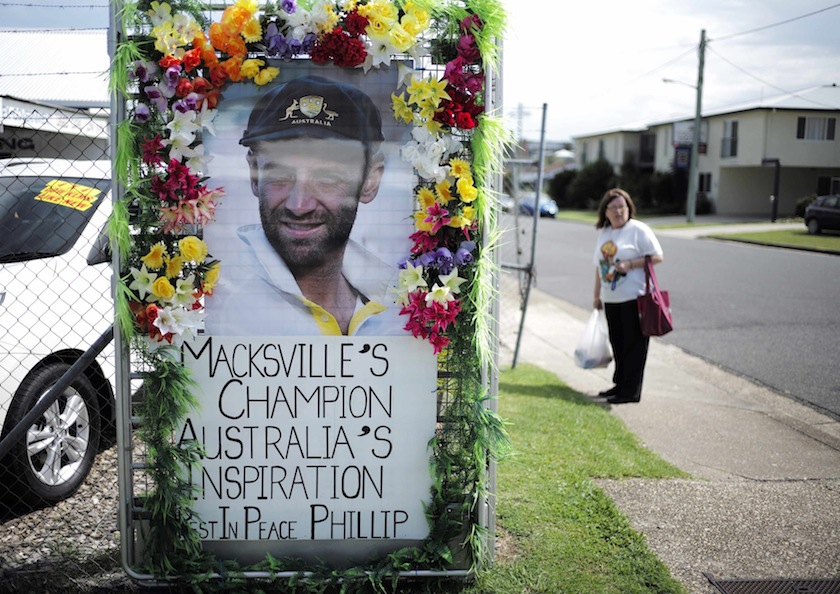 A local resident is pictured alongside a tribute to deceased Australian cricketer Phillip Hughes as his hometown prepares for his funeral in Macksville December 2, 2014. u00e2u20acu201du00c2u00a0Reuters pic