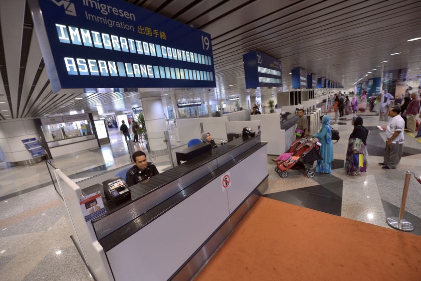 An immigration officer waits for tourists and travellers from Asean countries at the newly launched express lane at Kuala Lumpur International Airport, Sepang, December 18, 2014. u00e2u20acu201d Bernama pic