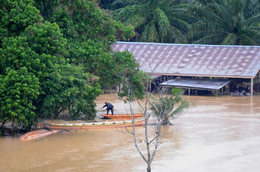 A villager at a flood-hit village in Kuala Kangsar is seen on his boat as he negotiates the flood waters, December 26, 2014. u00e2u20acu201d Picture by K.E. Ooi