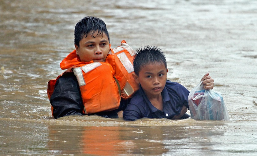 A policewoman helps a boy wade through floodwaters during heavy flooding brought by tropical storm Seniang in Misamis Oriental, Mindanao island in southern Philippines December 29, 2014. u00e2u20acu201d Reuters pic