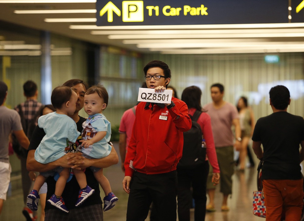 A Changi Airport staff holds up a sign to direct possible next-of-kin of passengers of AirAsia flight QZ 8501 from Indonesian city of Surabaya to Singapore, at Changi Airport in Singapore December 28, 2014. u00e2u20acu201d Reuters pic