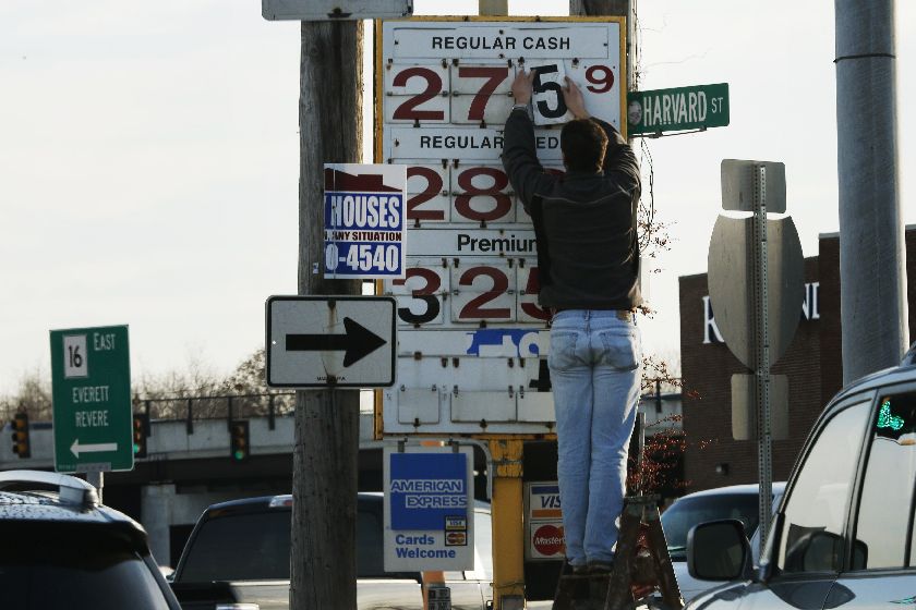 A man changes the price for a gallon of gasoline at a gas station in Medford, Massachusetts December 4, 2014. REUTERS/Brian Snyder