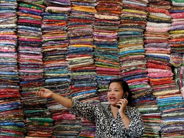 Malaysian businesswoman Fadhilah Arshad talks to a supplier as she sells cloth at her bazaar in Kuala Lumpur, December 2009. u00e2u20acu201d Reuters pic