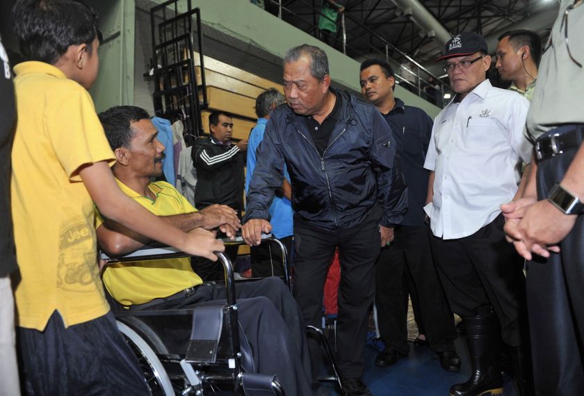 Deputy Prime Minister Tan Sri Muhyiddin Yassin (centre) and Pahang Mentri Besar Datuk Seri Adnan Yaakob (2nd right) speak to flood victims at a relief centre in Kuantan, December 26, 2014. u00e2u20acu201d Bernama pic