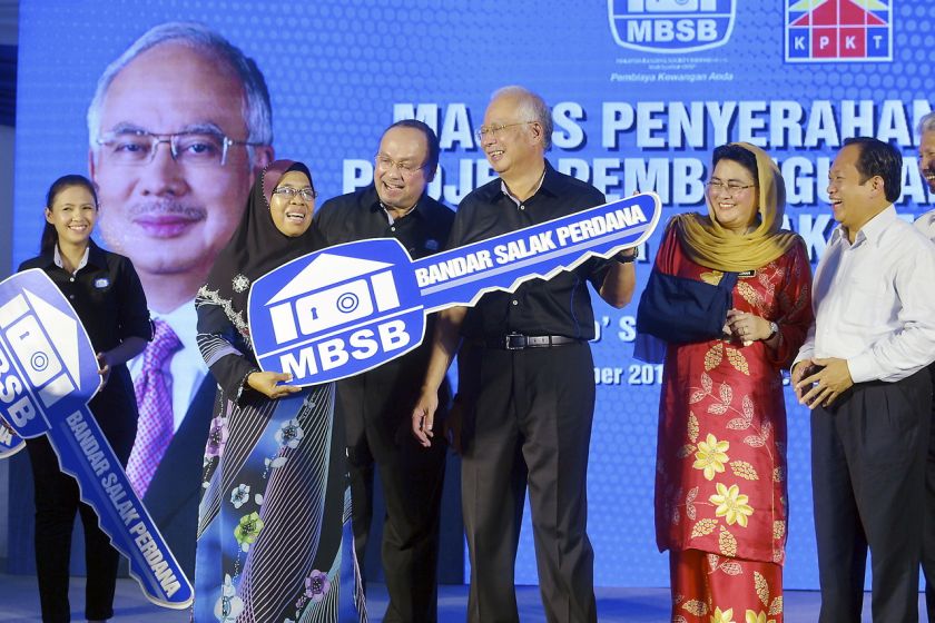 Prime Minister Datuk Seri Najib Razak symbolically handing over the keys to Nor Poziah Othman, one of the purchasers of houses in Bandar Salak Perdana, Sepang, December 18, 2014. u00e2u20acu201d Bernama pic