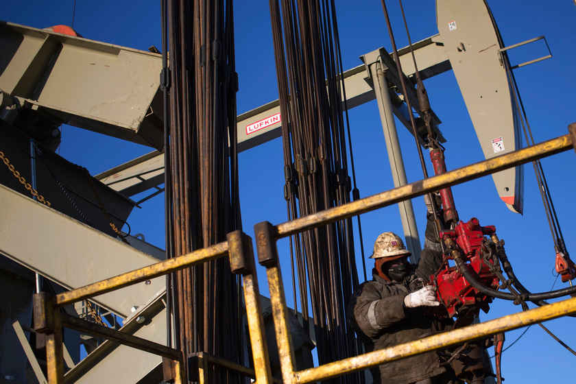 A man works on the rig of an oil drilling pump site in North Dakota, March 12, 2013. Oil is heading for its worst slump in six years. u00e2u20acu201d Reuters pic 