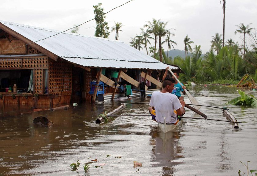 Residents paddle on a small boat to reach their homes in floodwaters brought on by heavy rains from tropical storm Jangmi, locally called Seniang, in Palo town, Samar province December 30, 2014. u00e2u20acu201d Reuters pic