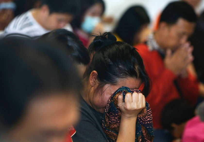 Relatives of passengers onboard AirAsia flight QZ8501 cry as they pray together in a waiting area at Juanda International Airport in Surabaya December 29, 2014. u00e2u20acu201d Reuters pic