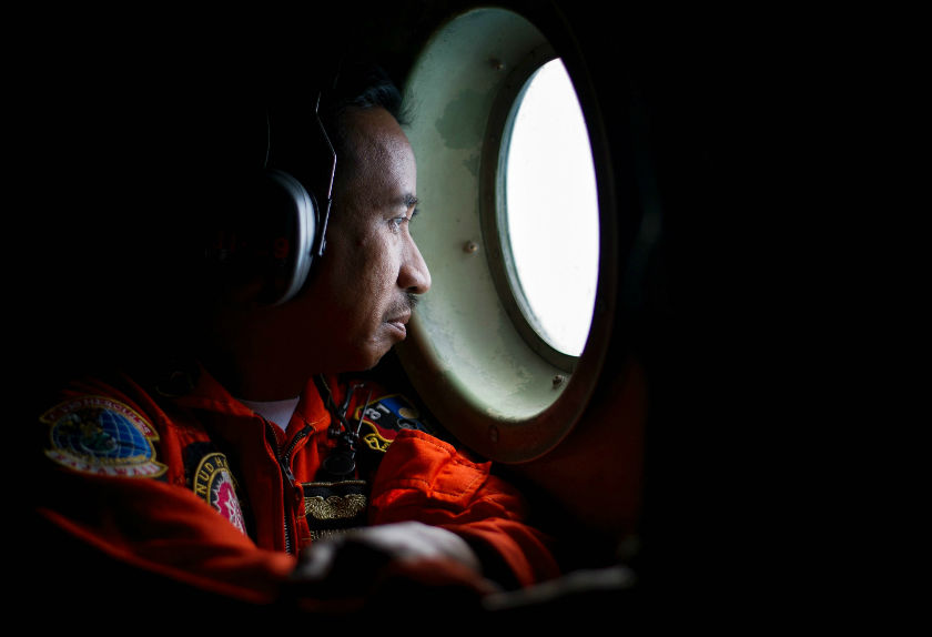 A member of an Indonesian Hercules C130 aircrew watches through a window while monitoring the Belitung Timur Sea during search operations for AirAsia flight QZ8501 near Belitung Island, December 29, 2014. u00e2u20acu201d Reuters pic