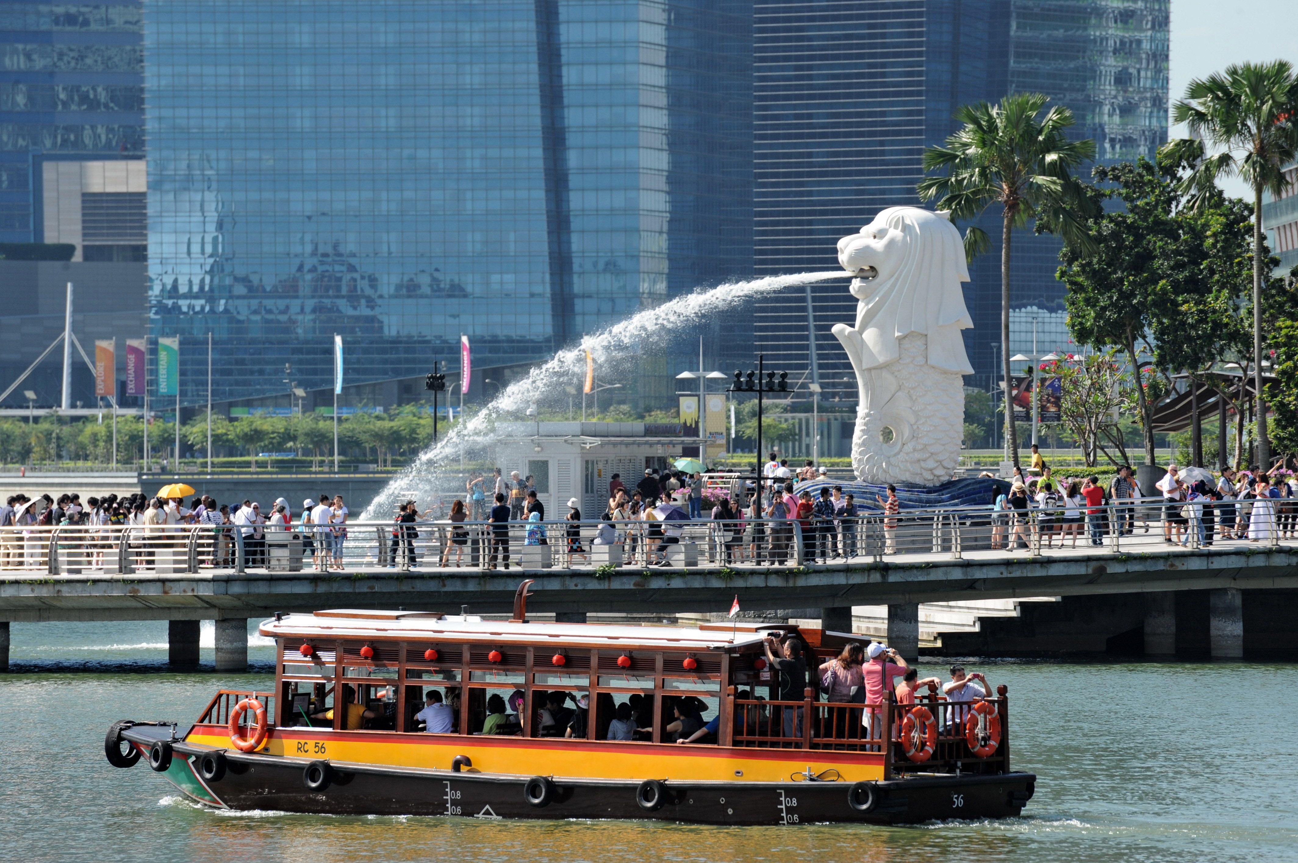 Tourists gather in front of the iconic statue of the Merlion in Singapore on February 8, 2012. u00e2u20acu201d AFP pic