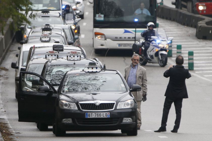 French motorcycle police escort striking Paris taxis which take part in a demonstration over the Paris ring road December 15, 2014. REUTERS/Charles Platiau
