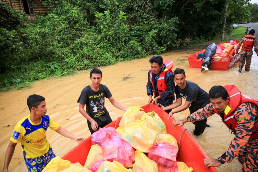 Fire and Rescue Department officers assist in distributing food items in Temerloh. u00e2u20acu2022 Picture by Saw Siow Feng