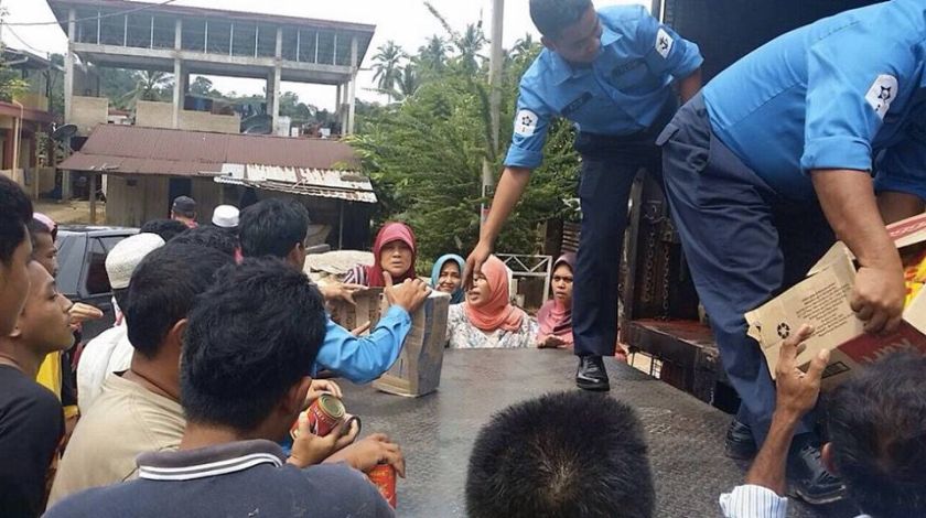 Royal Malaysian Navy personnel help to give out aid to flood evacuees in Kuala Krai, December 27, 2014. 