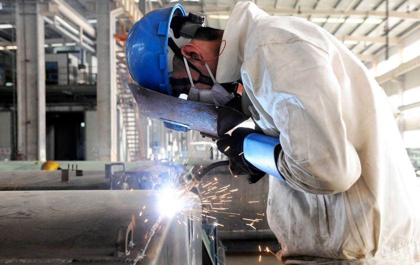 An employee welds the exterior of a vehicle in a Qingdao factory December 1, 2014. Economists expect China's November economic data to show a cooling trend. u00e2u20acu201d Reuters pic