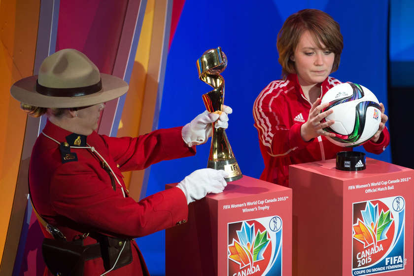 A Royal Canadian Mounted Police member carries the Women's World Cup trophy and player Talia Laroche the Official Match Ball during the draw for the Women's World Cup Canada 2015 in Quebec December 6 2014. u00e2u20acu201d Reuters pic