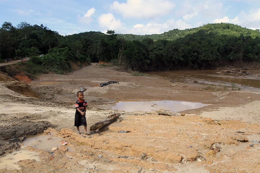 A child is seen walking on a former sand mine in Gua Musang. 