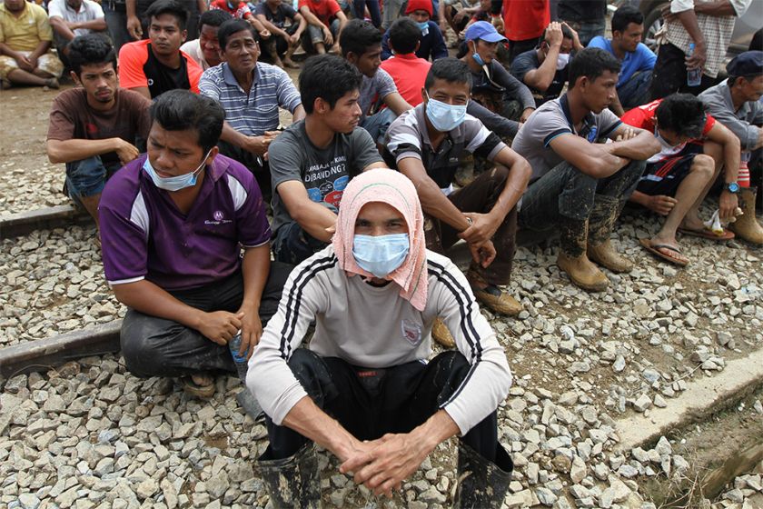Volunteers take a rest after helping to clean up the mess caused by the flood in Manek Urai.