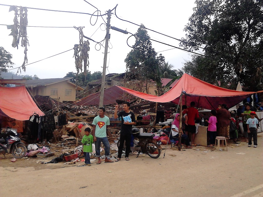Villagers are seen standing by the roadside waiting for aid at Kuala Krai, January 1, 2015. — Picture by Jules Ong