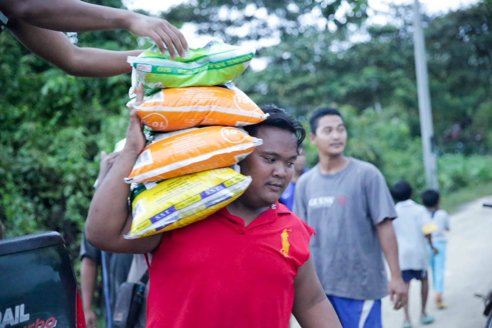 An Orang Asli villager carries three bags of rice over his shoulder in Mentakab, Pahang. —  Picture by Choo Choy May