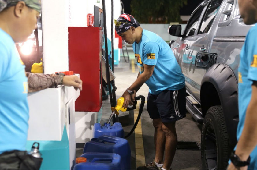 Volunteers from Mou Man Tai fill up large plastic containers with fuel to power the motorboats with which they will use to cross the floodwaters to remote Mentakab in Pahang January 3, 2015.