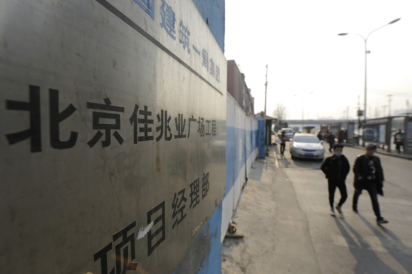 File picture of people walking past a construction site of Kaisa Plaza in Beijing, January 13, 2015. u00e2u20acu201d Reuters pic