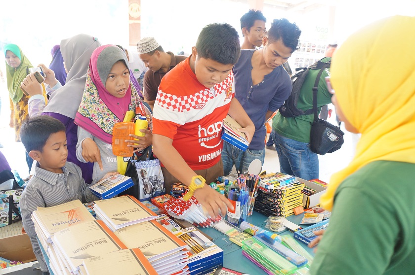Children asking a volunteer for sponsored stationery at the FreeMarket in Kuala Krai, Kelantan. February 14, 2015. u00e2u20acu201d Picture by Ida Lim