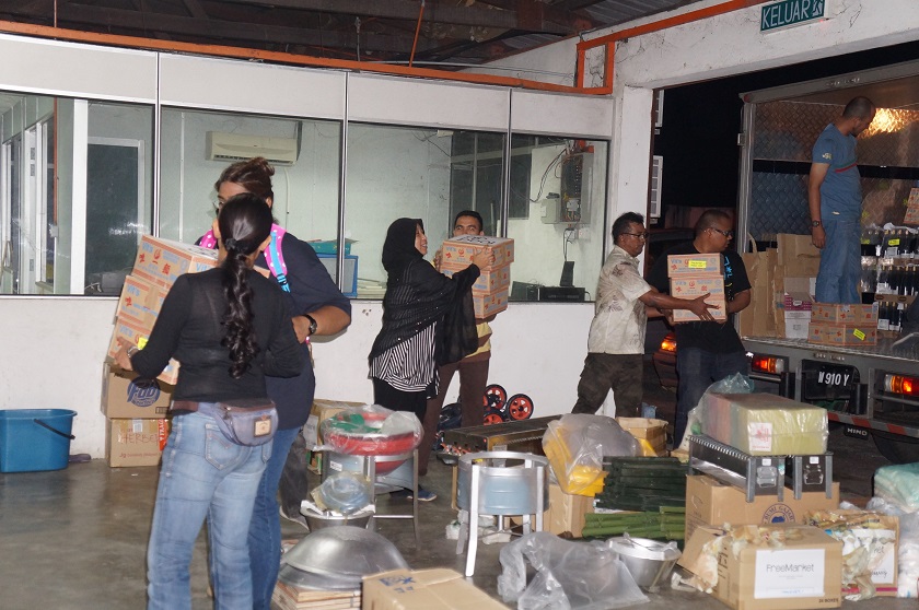 Volunteers forming a human chain and loading up a truck with sponsored items late at night for the FreeMarket. 