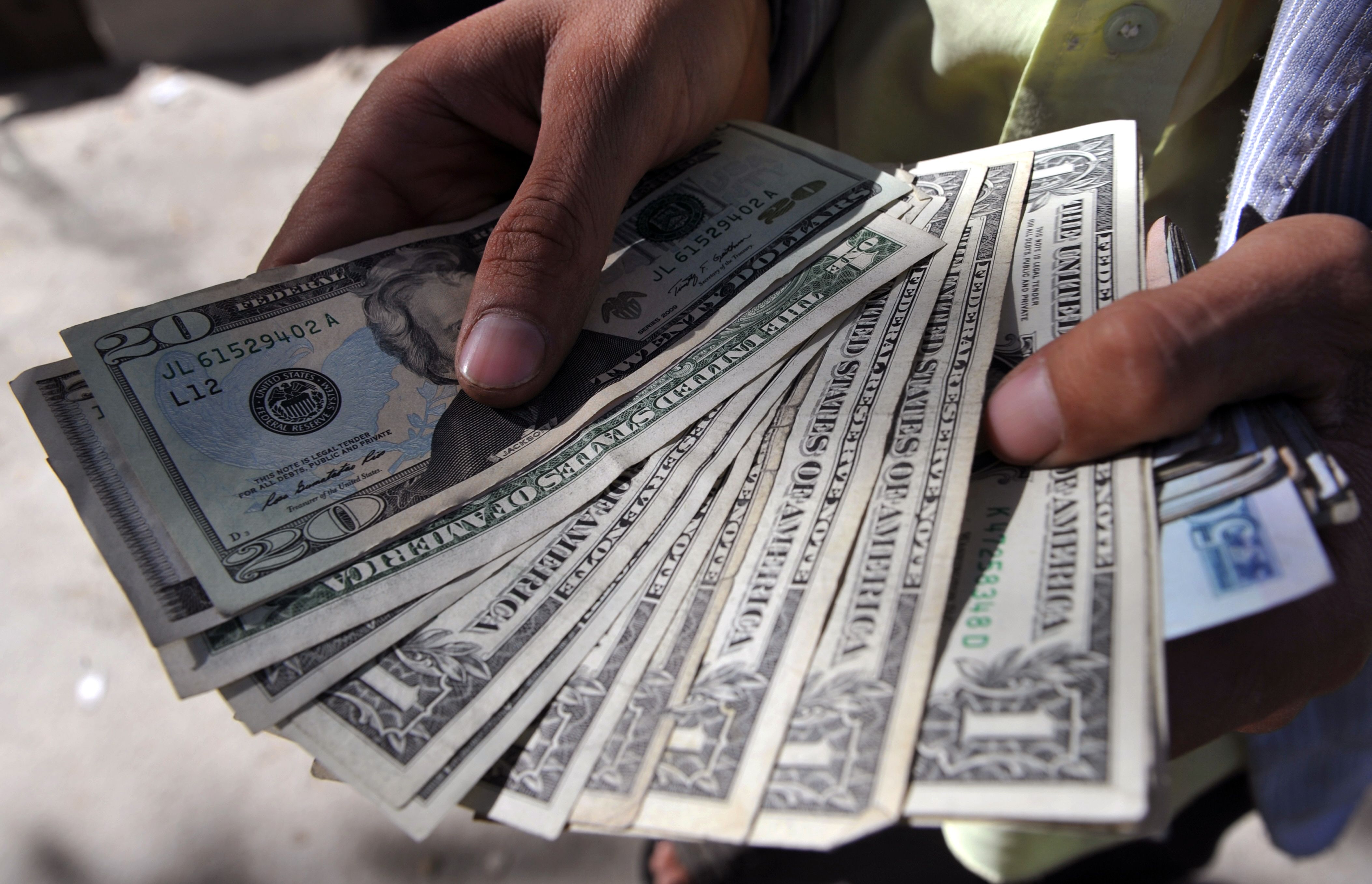 File picture of an Afghan moneychanger counts United States dollar (USD) currency notes on a street in Kabul on October 1, 2011. u00e2u20acu201d AFP pic
