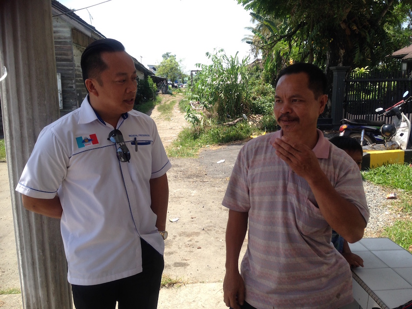 Jilius Yapoo talks to his village development and security chairman Michael Frederick after visiting SMK Kinarut and was told the school would send his four children, residing at the school's hostel, home for the day. — Picture by Julia Chan