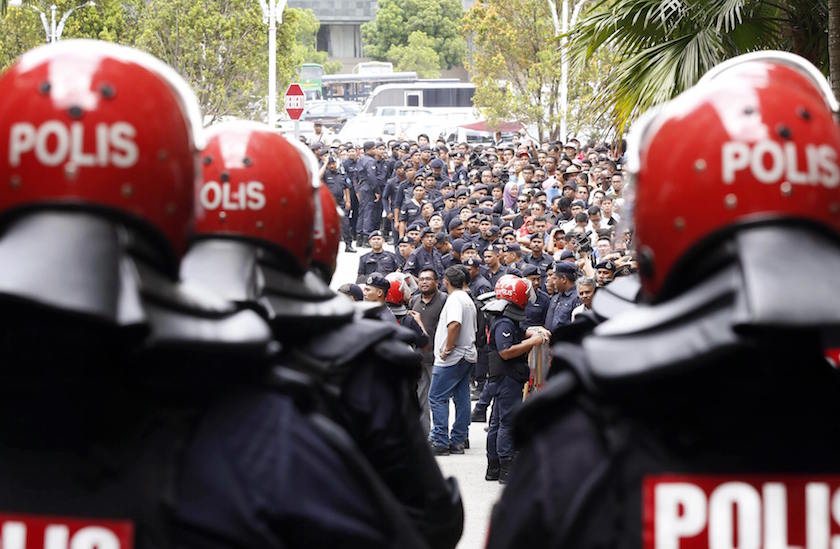 Supporters of Malaysian opposition leader Datuk Seri Anwar Ibrahim stand with police outside court in Putrajaya February 10, 2015. u00e2u20acu201d Reuters pic