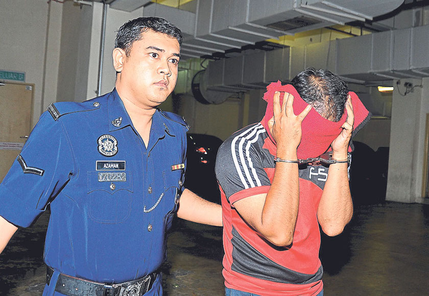 Muhammad Fazrul Fauzi, 30, is taken to court yesterday morning to be charged. u00e2u20acu201d Picture by Fikri Yusof