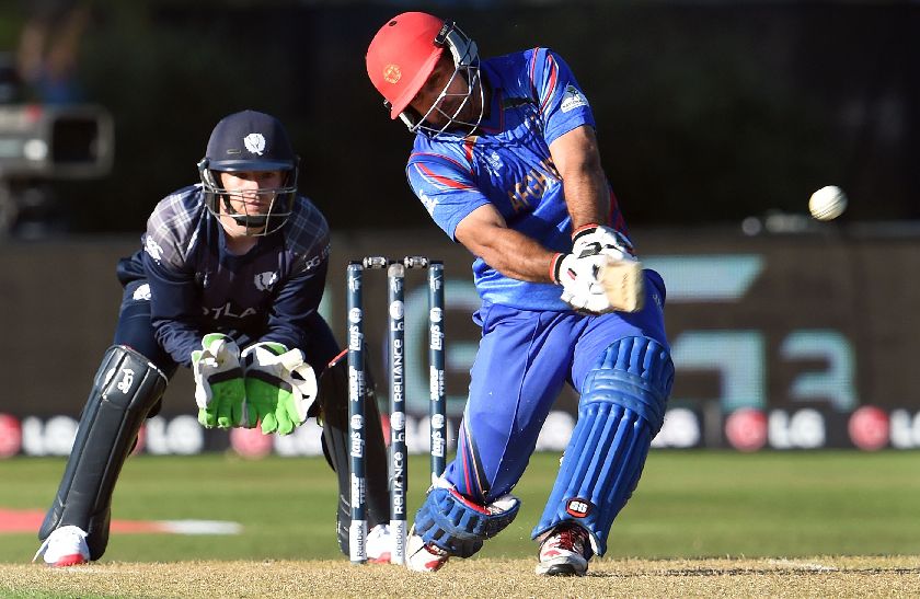 Afghanistan batsman Samiullah Shenwari (R) lofts the ball to a boundary, confounding Scotland wicketkeeper Matthew Cross (L) during their 2015 Cricket World Cup Group A match in Dunedin February 26, 2015. AFP PHOTO / William WEST