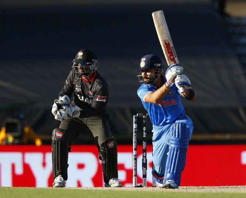 Indiau00e2u20acu2122s batsman Virat Kohli (R) drives a shot to point as United Arab Emiratesu00e2u20acu2122 wicket keeper Swapnil Patil watches in their Cricket World Cup match in Perth, February 28, 2015. REUTERS/David Gray