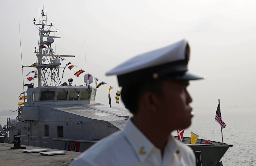 A Malaysian naval officer stands in front of a Bay Class Vessel patrol boat before a handover ceremony in Port Klang February 27, 2015. u00e2u20acu201d Reuters pic