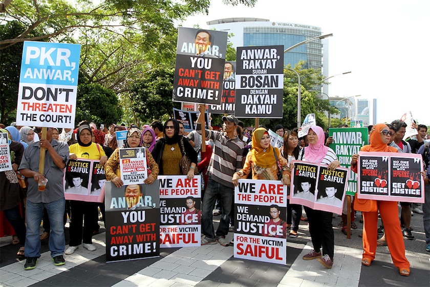 The group of mostly women with about 50 young men, who had their faces covered, held up placards bearing Saiful's face that read 'the real victim'. u00e2u20acu201d Picture by Yusof Mat Isa