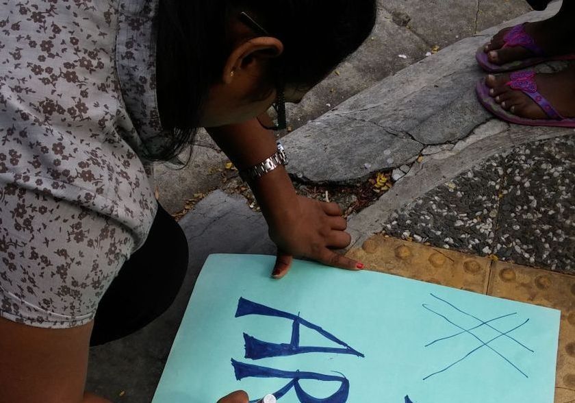A PSM member drawing on a placard demanding Arul's release. u00e2u20acu2022 Picture by Yiswaree Palansamy