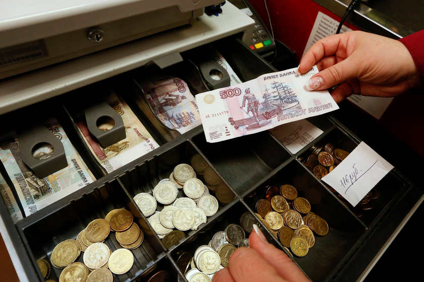 A cashier takes a 500-rouble banknote as she serves a customer in Krasnoyarsk. The Russian rouble climbed five per cent yesterday (February 3, 2015). u00e2u20acu201d Reuters picn