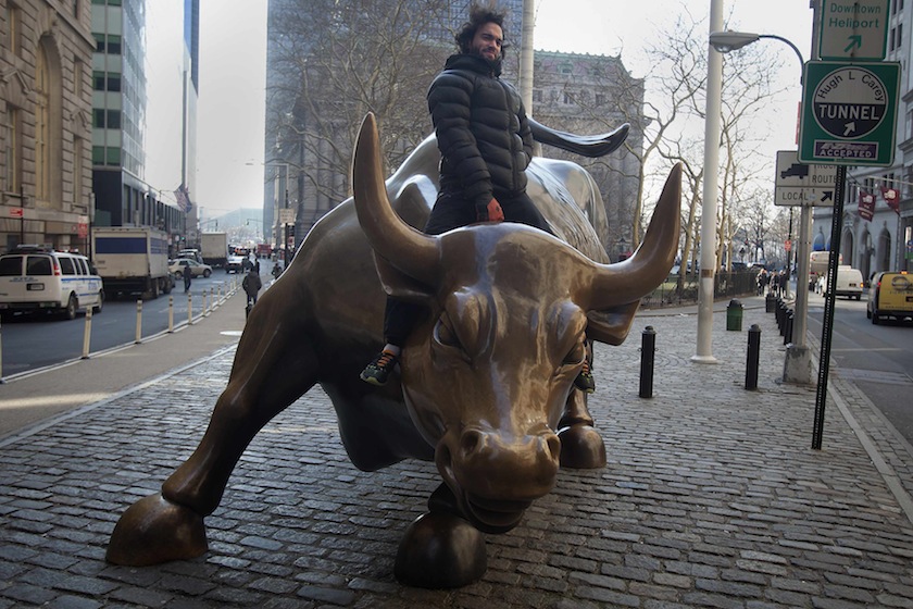 A tourist mounts the 'Charging Bull' statue as he poses for a photo near Wall Street, in the Manhattan borough of New York January 16, 2015. u00e2u20acu201d Reuters pic