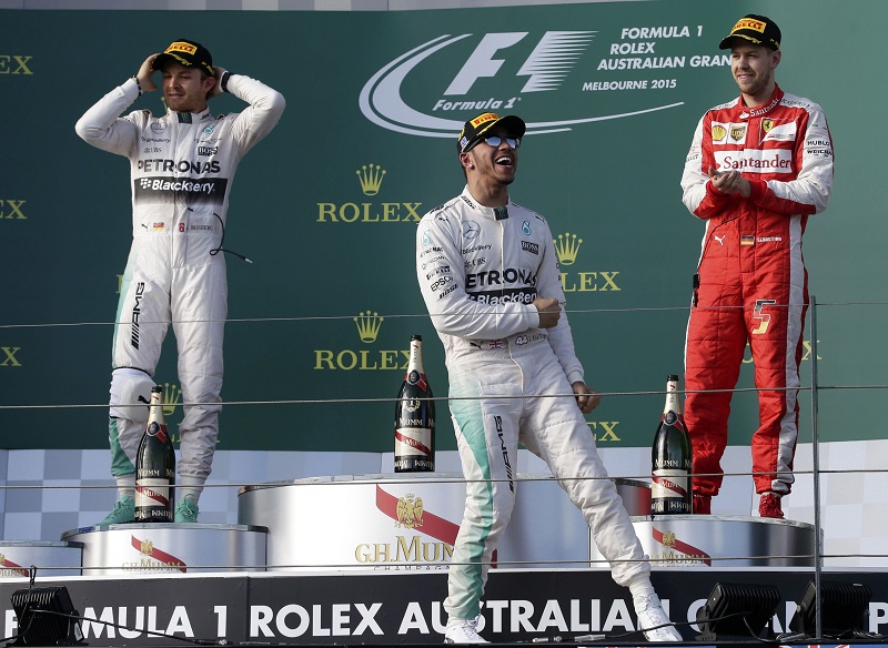 Mercedes Formula One driver Lewis Hamilton of Britain (centre) celebrates his victory on the podium next to second placed Nico Rosberg of Germany and third placed Ferrari Formula One driver Sebastian Vettel of Germany (right) after the Australian F1 Grand