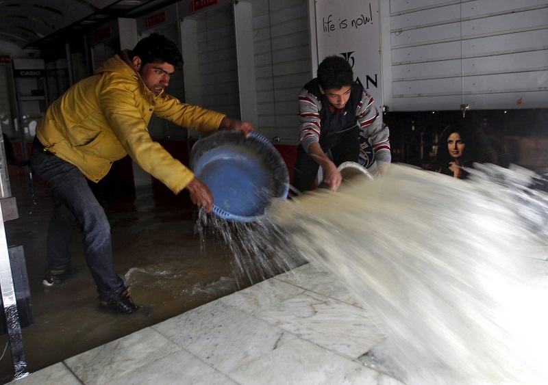 Men remove water from a water-logged shop after incessant rains in Srinagar March 29, 2015. u00e2u20acu201d Reuters pic